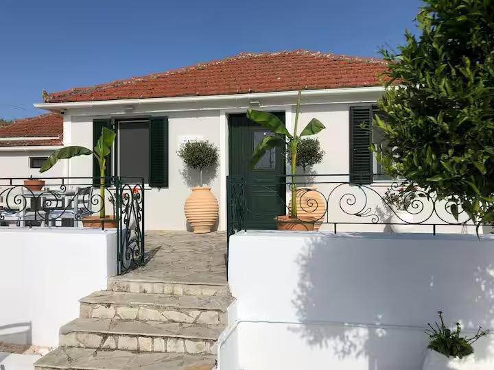 Lilac House front entrance with green shutters and olive trees